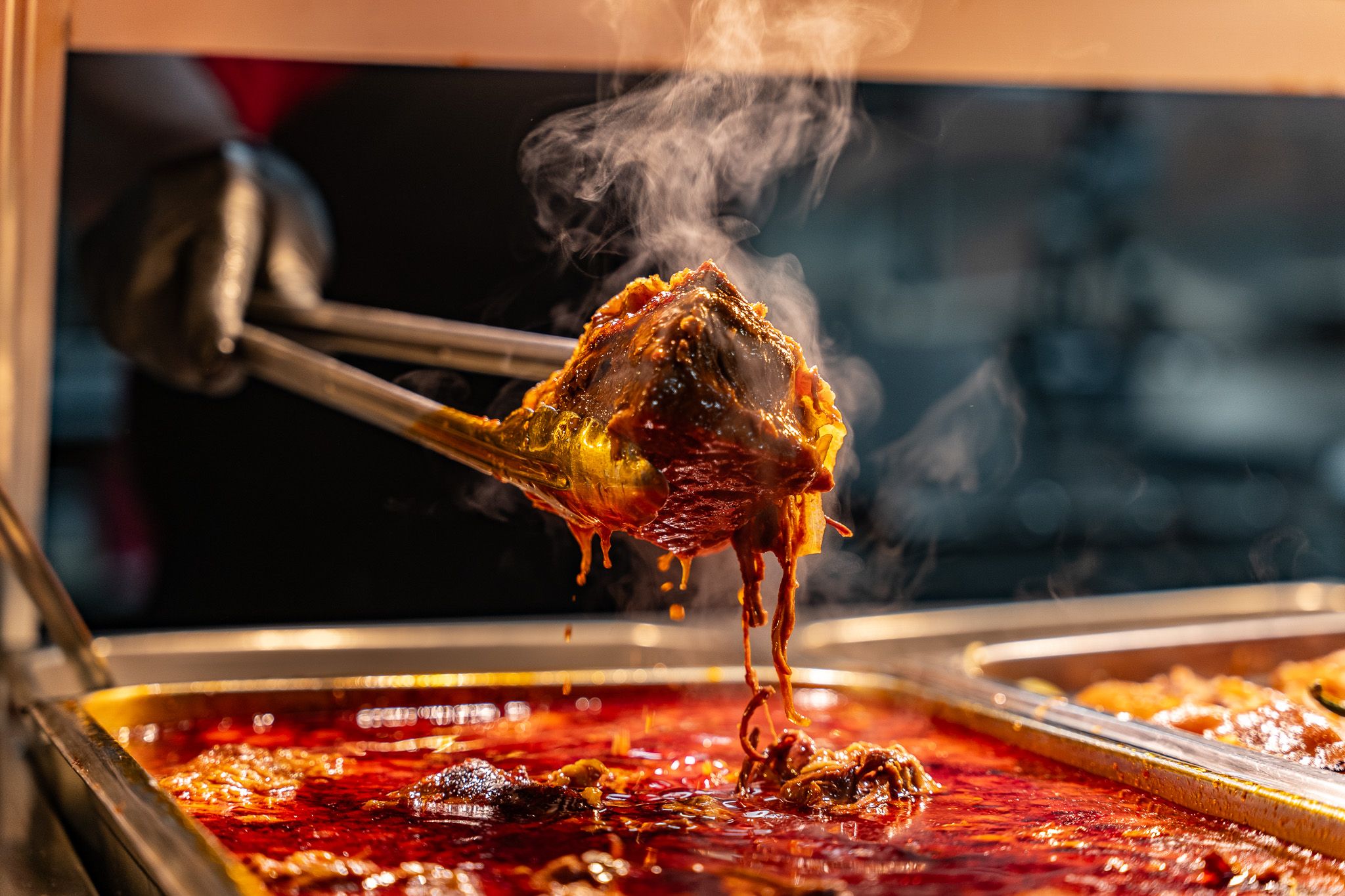 Steaming serving of saucy guisado lifted from the hot deli line at Carnicería 99