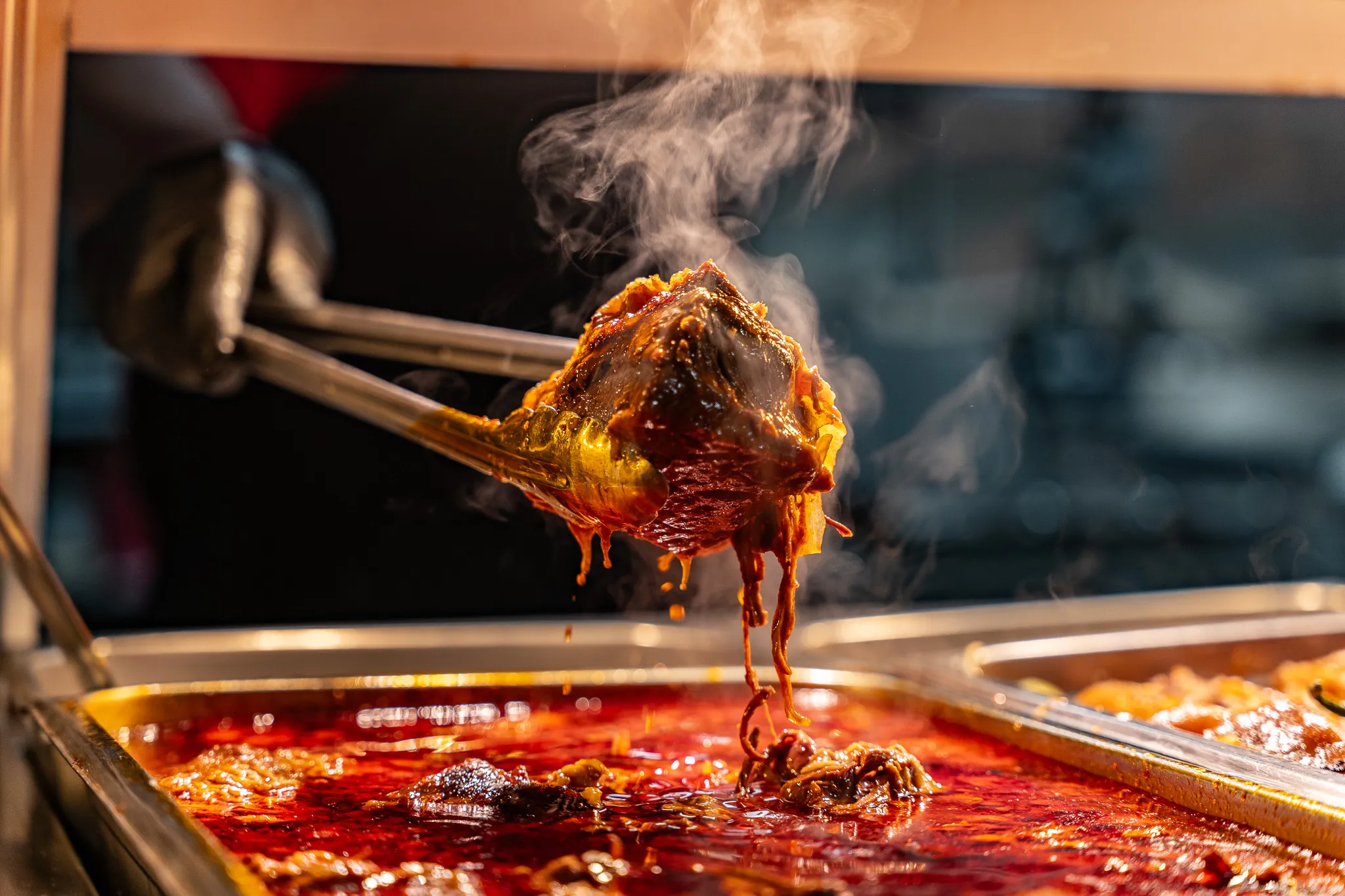 Steaming serving of saucy guisado lifted from the hot deli line at Carnicería 99