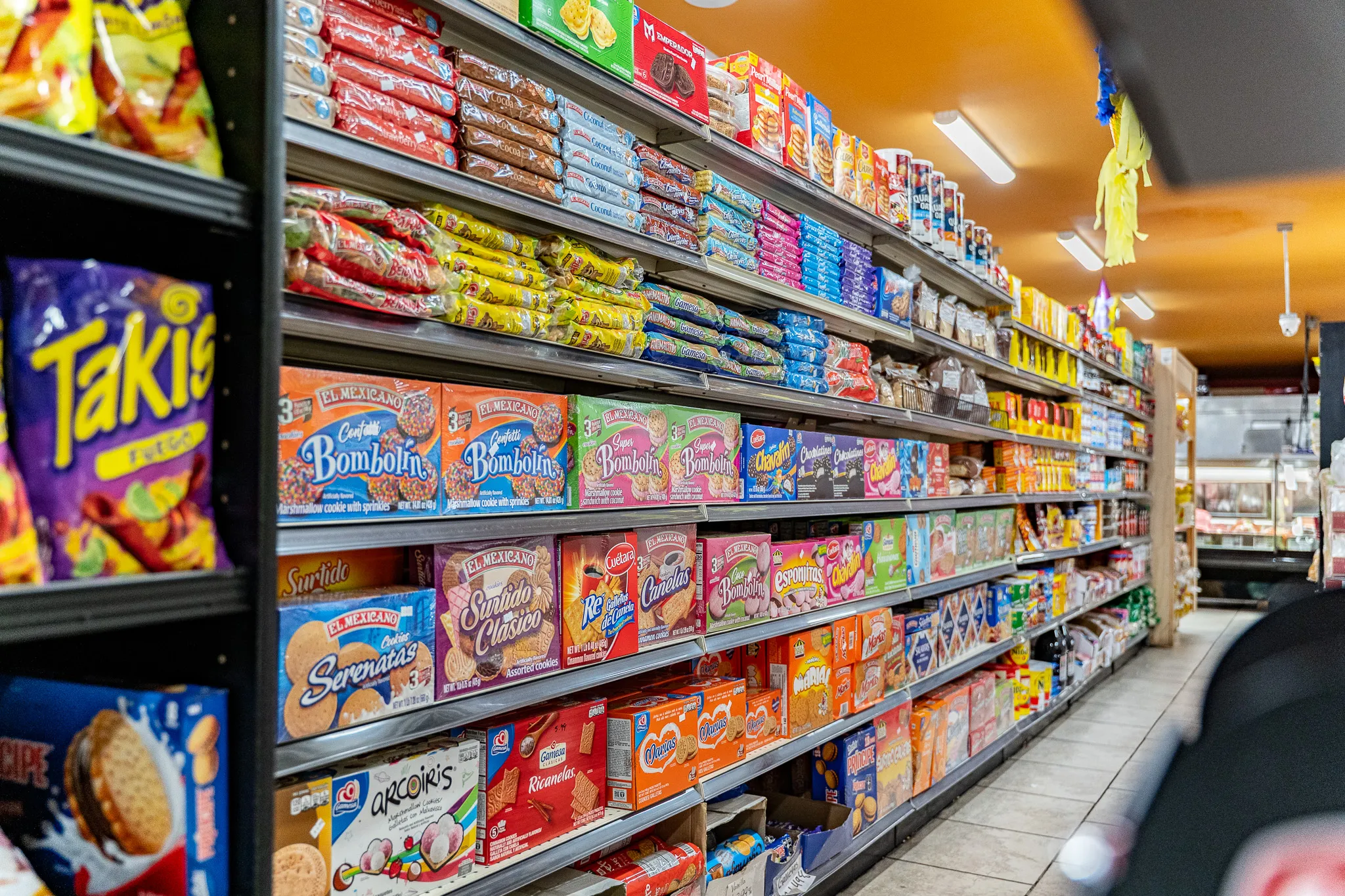Brightly stocked grocery aisle of authentic Mexican products at Carnicería 99